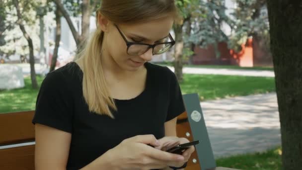 Szép Kaukázusi Szemüvegek Használata Fekete Mobiltelefon Üljön Padon Városi Parkban — Stock videók