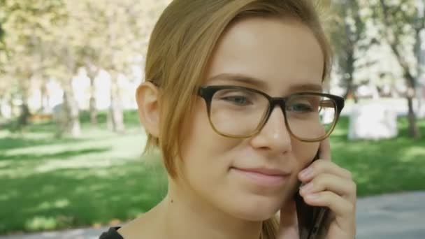 Feliz Joven Mujer Caucásica Gafas Hablando Teléfono Celular Negro Mientras — Vídeos de Stock