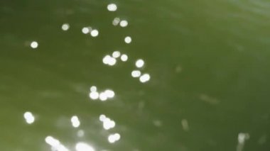 Güneşte parıldayan küçük deniz dalgaları. Yansıyan güneş fişekleri güzel bir bokeh ile dalgalı bir su yüzeyinin defocused atış. Soyut bulanık odak bokeh arka plan görüntüleri dışında.
