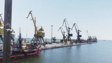 Deniz limanı vinçleri. Yaz aylarında ticari liman çelik. Kentsel peyzaj. Limanda kargo gemisi. Tersanede geminin inşaatı 
