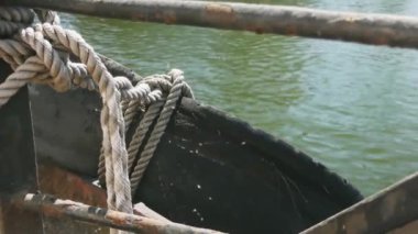 Yakın çekim deniz düğümü halatı tekne veya gemi, tekne demirleme halatı kazık etrafında bağlı. Gemide deniz ipi var. Gemi limandan ayrılıyor. Deniz feneri. Demirleme ipi. Limanda gemi. 