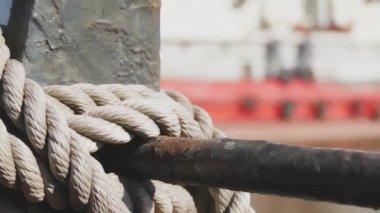Yakın çekim deniz düğümü halatı tekne veya gemi, tekne demirleme halatı kazık etrafında bağlı. Gemide deniz ipi var. Gemi limandan ayrılıyor. Deniz feneri. Demirleme ipi. Limanda gemi. 