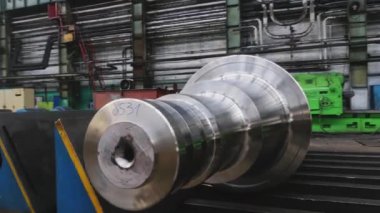 Çelik rulolar, fabrikanın üretim atölyesinde zemine uzanır. Çelik ürünlerin imalatı. Haddeleme şekillendirme rulo metal işleri. Haddehane hazırlama atölyesi. Makine parçalarının işlenmesi