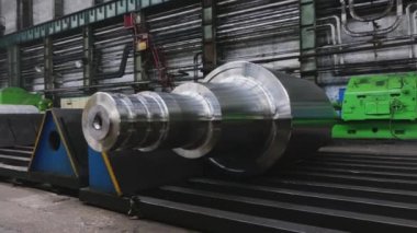 Çelik rulolar, fabrikanın üretim atölyesinde zemine uzanır. Çelik ürünlerin imalatı. Haddeleme şekillendirme rulo metal işleri. Haddehane hazırlama atölyesi. Makine parçalarının işlenmesi
