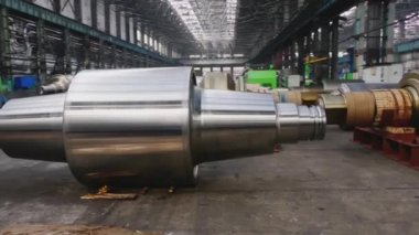 Çelik rulolar, fabrikanın üretim atölyesinde zemine uzanır. Çelik ürünlerin imalatı. Haddeleme şekillendirme rulo metal işleri. Haddehane hazırlama atölyesi. Makine parçalarının işlenmesi
