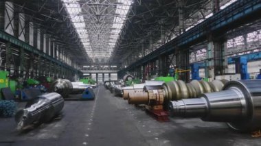 Çelik rulolar, fabrikanın üretim atölyesinde zemine uzanır. Çelik ürünlerin imalatı. Haddeleme şekillendirme rulo metal işleri. Haddehane hazırlama atölyesi. Makine parçalarının işlenmesi