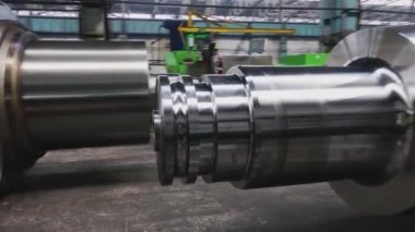 Çelik rulolar, fabrikanın üretim atölyesinde zemine uzanır. Çelik ürünlerin imalatı. Haddeleme şekillendirme rulo metal işleri. Haddehane hazırlama atölyesi. Makine parçalarının işlenmesi