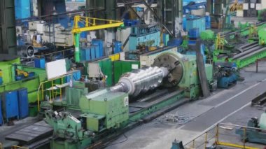 Büyük rulo fabrikada metal haddeleme makinesi üzerinde oluşturulur. Profillerin oluşturulması, çelik sacdan rulo oluşturma makinesi. Haddehane hazırlama atölyesi. Makine parçalarının işlenmesi.