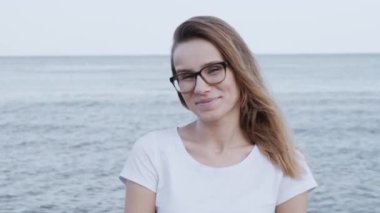 çekici genç beyaz kadın kamera bakıyor ve kendine güvenen güzel gülümseyen yakın portre. 