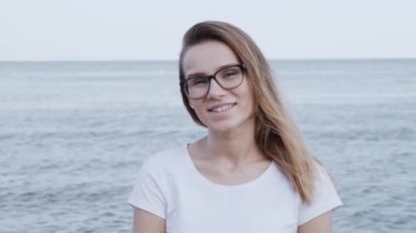 çekici genç beyaz kadın kamera bakıyor ve kendine güvenen güzel gülümseyen yakın portresi. kız iyi haber sevinir