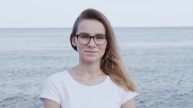 çekici genç beyaz kadın kamera bakıyor ve kendine güvenen güzel gülümseyen yakın portre. 
