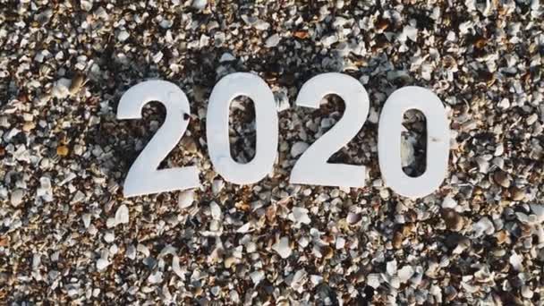 2020년 해에는 바닷가의 사이로 모래에 숫자가 씻겨나간다 해변에 2020 개념이 — 비디오