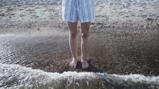 女人的腿在日落时分在海水中跳跃 女性双腿在沙滩上跳入海水 度假理念 — 图库视频影像