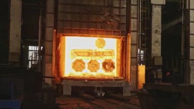 Bir mühendislik tesisinde kene kaynaklı vinç le çalışır. Vinç dövme pres içine taşımak için sıcak çelik kütükleri kaldırır.