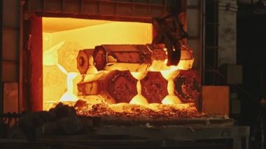 Bir mühendislik tesisinde kene kaynaklı vinç le çalışır. Vinç dövme pres içine taşımak için sıcak çelik kütükleri kaldırır.