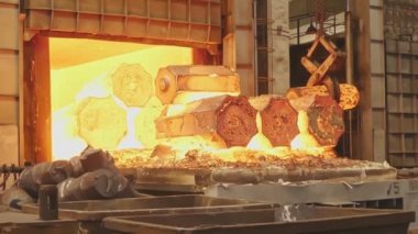 Bir mühendislik tesisinde kene kaynaklı vinç le çalışır. Vinç dövme pres içine taşımak için sıcak çelik kütükleri kaldırır.