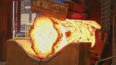 Erimiş metal boş. Kütük demirci basında dövülür. Makine Dökümhane'de Kesme Çelik Çubuğu'nu Çekiçler. karanlık atölyede çok sıcak demir çubuk kesme büyük mekanik demirci çekiç kaybetmek.