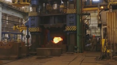 Erimiş metal boş. Kütük demirci basında dövülür. Makine Dökümhane'de Parlayan Çelik Çubuğu Çekiçler. Büyük mekanik demirci çekiç karanlık atölyede çok sıcak demir bar forges.