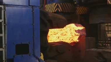 Erimiş metal boş. Kütük demirci basında dövülür. Makine Dökümhane'de Parlayan Çelik Çubuğu Çekiçler. karanlık atölyede çok sıcak demir bar demir demirci demirci demirci kadar kaybetmek.