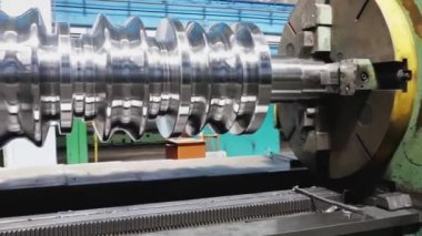 Fabrikadaki metal haddeleme makinesinde büyük rulo. Yakından kapatın. Haddehane hazırlama atölyesi. Makine parçalarının işlenmesi.