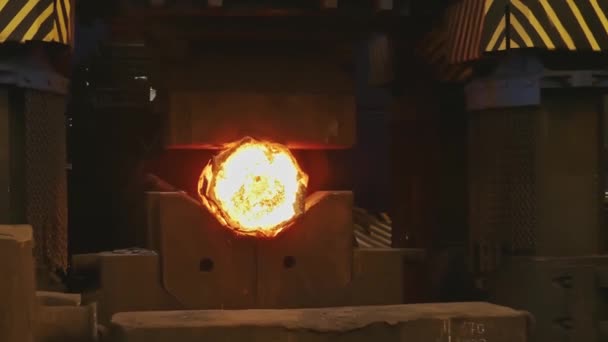 熔融金属空白 比利特用铁匠锻造了新闻界 机器锤在铸造厂中磨一个发光的钢筋 失去大型机械铁锤锻造非常热的铁棒在黑暗的车间 — 图库视频影像
