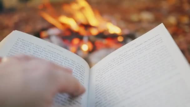 女性の手は本のページをたき火に対してオンにします クローズアップ 一人称視点 — ストック動画