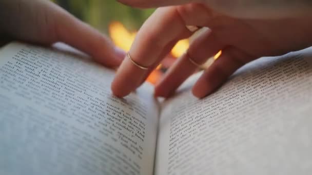 Una Mano Femenina Gira Las Páginas Libro Contra Una Hoguera — Vídeo de stock