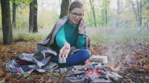 Egy Kempingezik Erdőben Ősszel Tábortűznél Üldögél Fiatal Fehér Beszél Telefonon — Stock videók