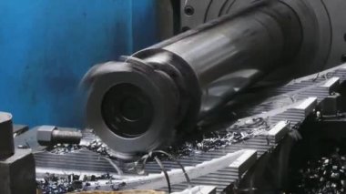 Çelik rulo yufklayan bir Cnc makinesinin yakın çekim. Bükümlü yongalar metal şekillendirme işlemi sırasında çelik metal bir parça kapalı uçan gelir. Makine atölyesinde torna aleti tıraşı. 