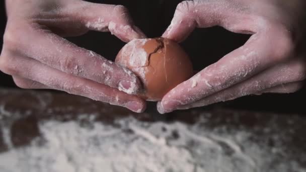 Gros plan de femme chef craquant oeuf dans la farine. Mouvement lent de la chute des œufs dans le bouillon de farine. De la nourriture. Œuf tombant dans la farine, au ralenti. Yolk Falls. Blog alimentaire, Produits à base de farine — Video