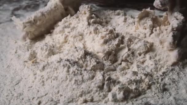 Baker amassar massa de farinha na mesa. Processo de mistura de farinha com ovo e massa de amassar. — Vídeo de Stock