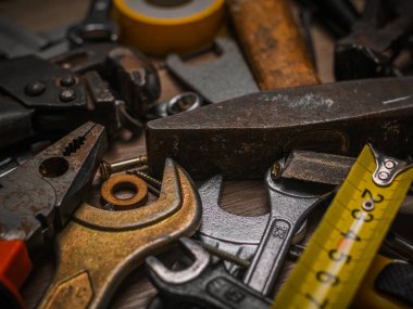 İnşa ve ölçüm aletleri. Ahşap bir panelin üzerinde alet seti. Ahşap masanın üzerinde mavi çizgili inşaat araçları