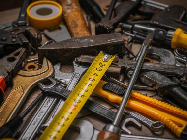 İnşa ve ölçüm aletleri. Ahşap bir panelin üzerinde alet seti. Ahşap masanın üzerinde mavi çizgili inşaat araçları