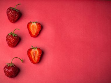 Pembe arka planda renkli çilek deseni. Yaratıcı gıda konsepti. Boşluğu kopyala