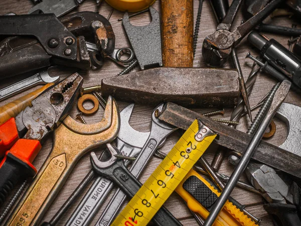 Building and measuring tools. Set of tools over a wood panel. Construction Tools With Blueprint On Wooden Desk