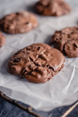 Çamaşır beyazlatılmamış parşömen kağıdında çikolatalı kurabiye. Çikolatalı kurabiyeler ve kurabiye kağıdı. Kapatın. Boşluğu kopyala