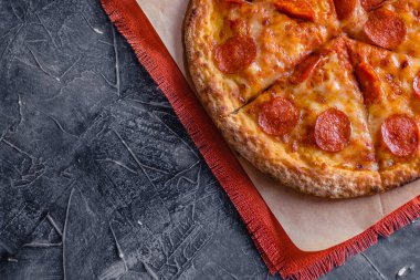 Lezzetli biberli pizza ve siyah beton arka planda domates fesleğeni. Acı biberli pizzanın en iyi manzarası. Metin için kopyalama alanı ile. Düz yatıyordu