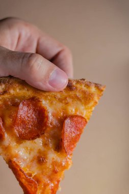 Erkek el, pepperoni pizzasının ilk dilimini teslimat kutusundan çıkarır. Fast food konsepti.
