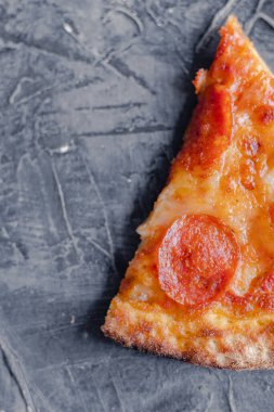 Siyah arka planda Pepperoni pizza dilimi. Bir dilim pepperoni pizza, üstten fotokopi.