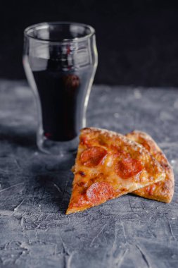 Siyah tahtada pizza dilimleri, geleneksel İtalyan pizzası, bir bardak kola..