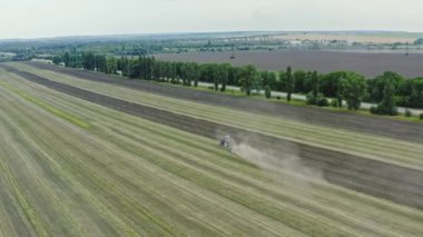 Traktörün üzerine hava manzarası serpmek köydeki araziyi sürükler. Toprağı ekime hazırlama süreci.