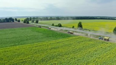 Traktörlerin tarladaki hava görüntüleri boşaltma için mahsulü taşıyor. Köyde hasat..