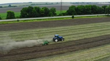 Traktörün hava görüntüsü köydeki araziyi tarıyor. Toprağı ekime hazırlama süreci.