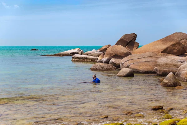 Великі жовті скелі в морі проти блакитного неба. плаваюча людина — стокове фото