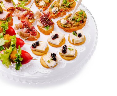 Zarif bir tabakta çeşitli tapaların canlı bir yayılımı sergileniyor. Renkli malzemeler ve çeşitli malzemeler canlı bir etkinlikte misafirler için davetkar bir gösteri oluşturur..