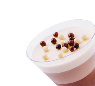 Küçük çikolata topları ve meyve parçalarıyla kaplı lezzetli çikolata ve krema katmanları. Temiz bir cam bardakta servis edilir, davetkar ve cezbedici görünür..