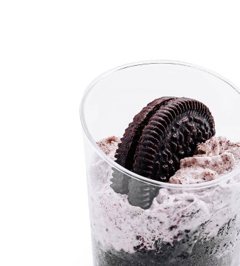 Krem şanti katmanlı lezzetli bir tatlı ve üstüne de bütün Oreo kurabiyesini serpiştirilmiş. İkram, cezbedici bir manzara sunan açık bir bardakta sunuluyor..