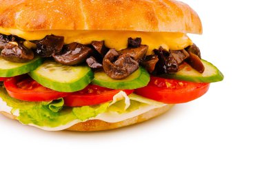 Marul, domates, salatalık, peynir ve sote mantarlardan oluşan bir sandviçin yakından görüntüsü.