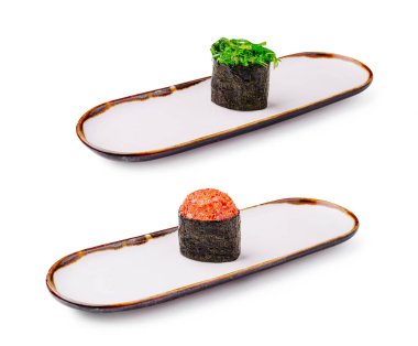 Zarif beyaz tabaklarda sunulan iki farklı suşi rulosu. Üst rulo canlı yeşil bir üst içerir, alttaki ise çarpıcı turuncu bir tane, her ikisi de güzelce düzenlenmiş..