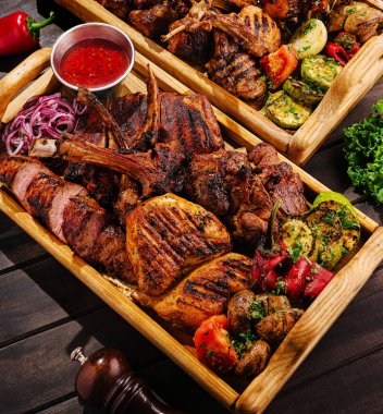 Ağız sulandıran bir barbekü tabağında taze sebze ve sos eşliğinde tavuk, biftek ve kuzu eti de içeren bir dizi ızgara et sergileniyor. Arkadaşlarla bir yaz ziyafeti için mükemmel..